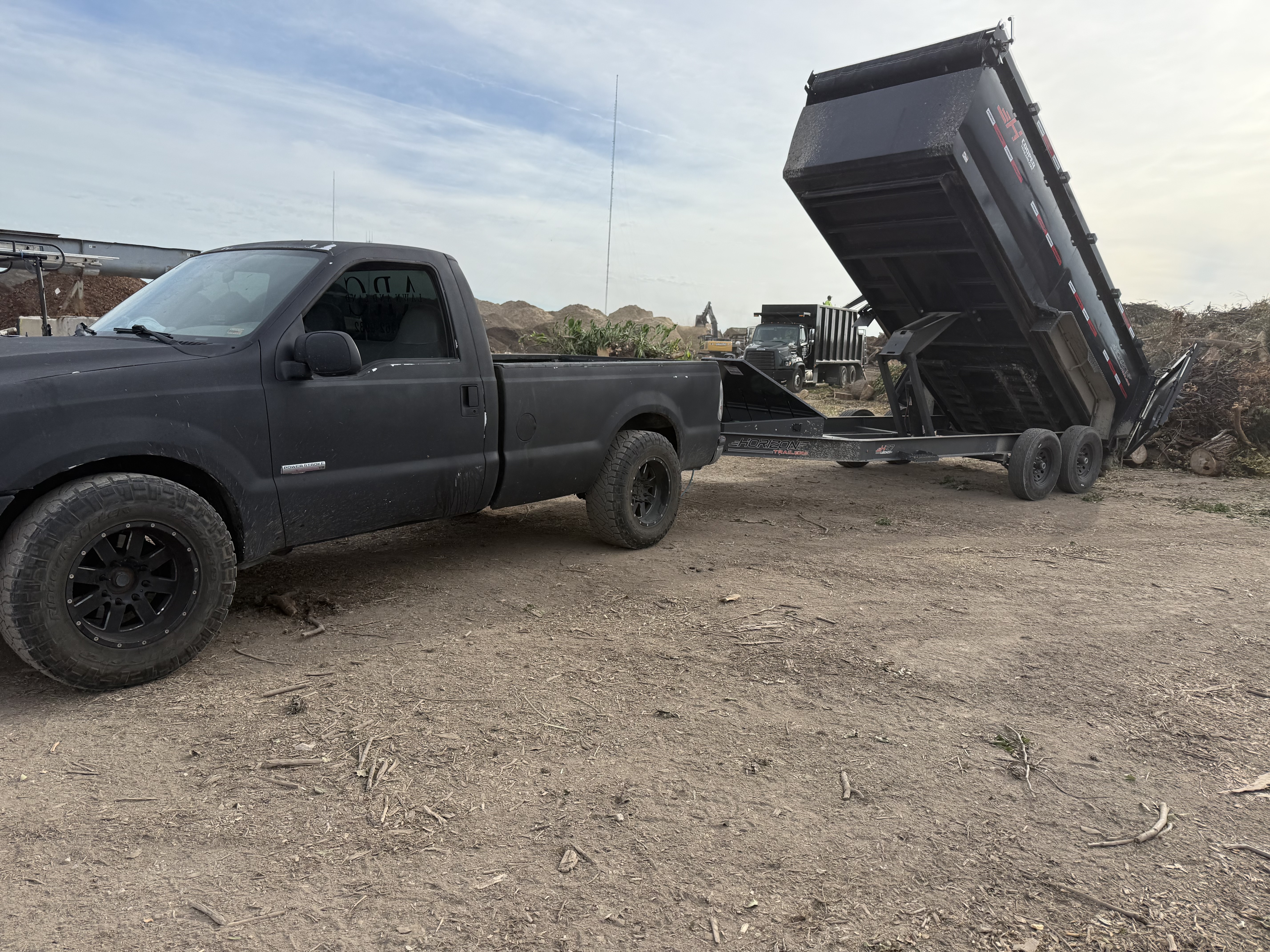 ARC Lawn and Land truck and dump trailer loading mulch at the yard
